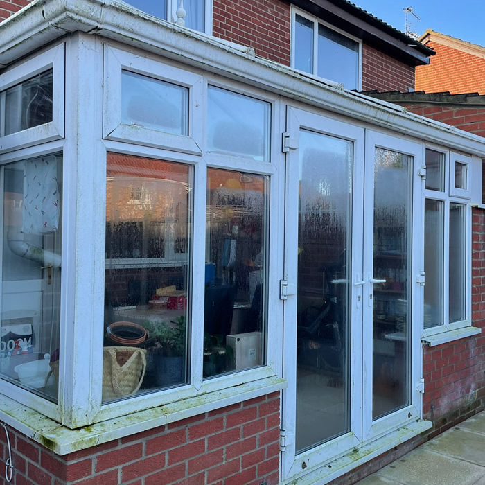 Dirty white uPVC conservatory extension, doors, windows and gutters